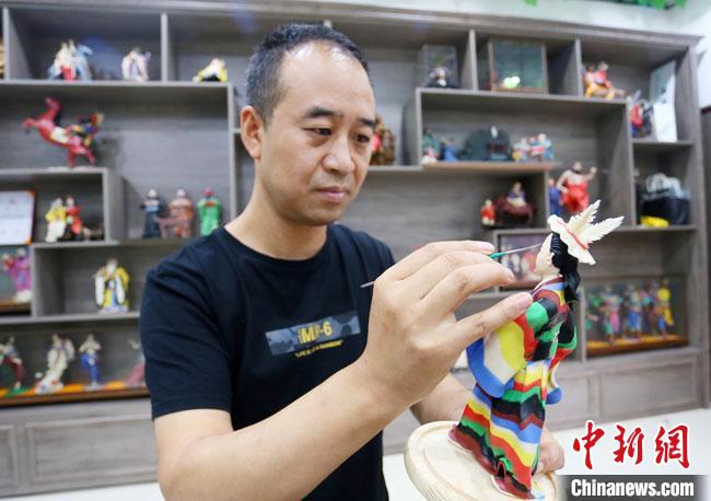 圖為安秋平正在創(chuàng)作代表隴南文縣民俗的《白馬人》作品?！「哒?攝