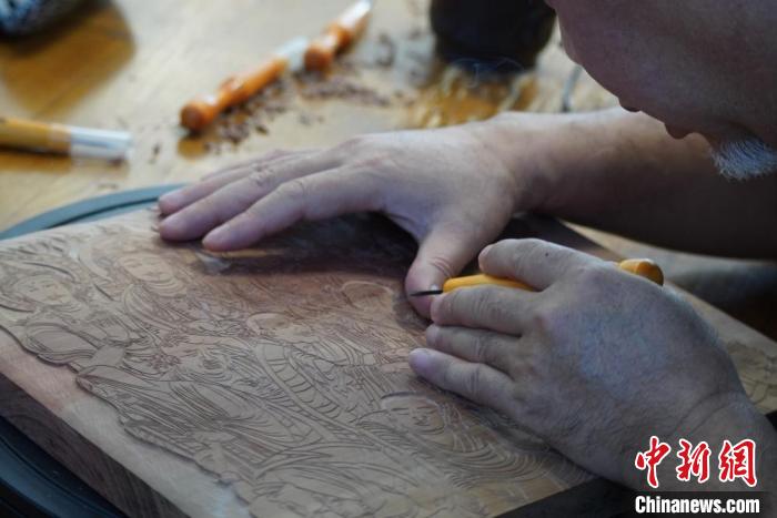 圖為徐晉林湊近木板，近距離制作雕版畫。　九美旦增 　攝