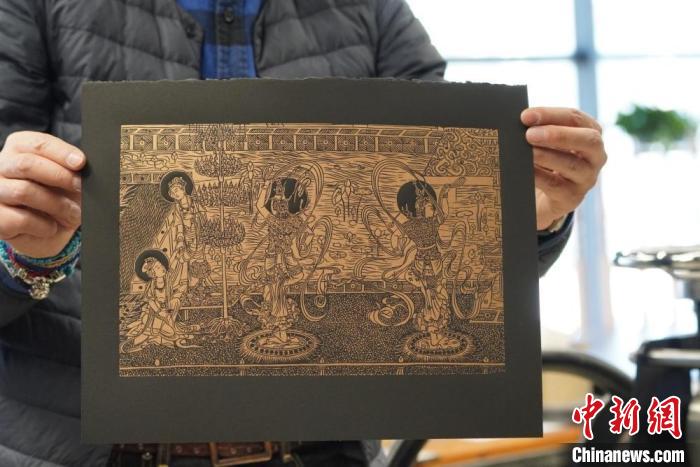 圖為手工書藝人展示敦煌雕版壁畫印刷品?！【琶赖┰?　攝