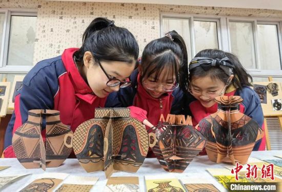 圖為學生用紙創(chuàng)作的立體彩陶?！⒂裉?攝