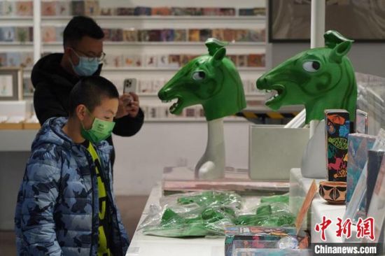 圖為“神馬來(lái)了”銅奔馬頭套吸引參觀者駐足?！【琶赖┰?攝