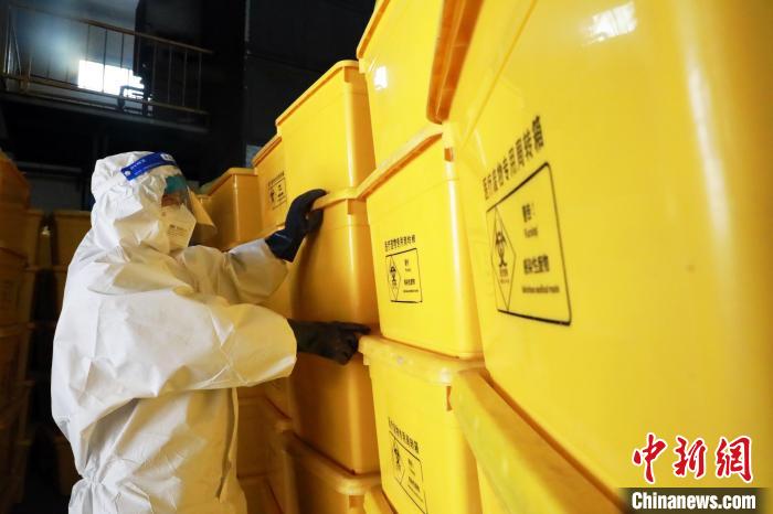 圖為工作人員搬運(yùn)醫(yī)療廢物專用周轉(zhuǎn)箱?！∥航ㄜ?攝