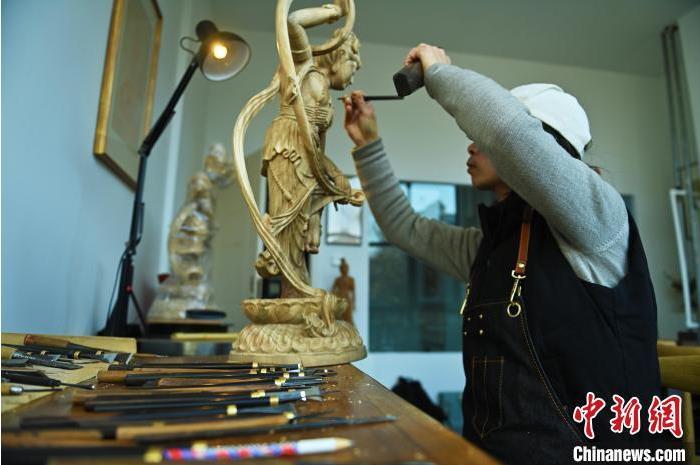 圖為季茂杰進行敦煌元素的木雕創(chuàng)作。李亞龍 攝</p>
<p>