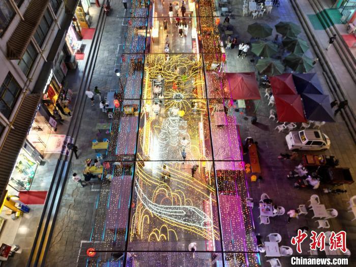 圖為明清街夜市燈光點亮具有武威文化元素的“天梯山石窟”彩燈。(無人機照片) 　戴文昌 攝</p><p>