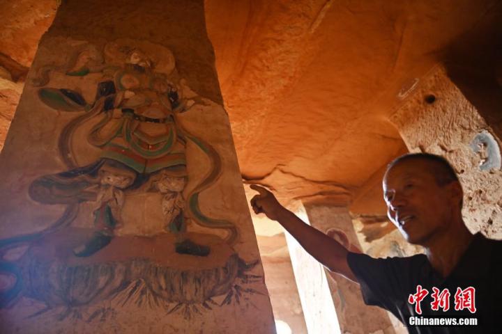 7月15日，甘肅省平?jīng)鍪袥艽h百里石窟長廊羅漢洞石窟內(nèi)，該窟文保員郭建平介紹窟內(nèi)石刻彩繪壁畫。郭建平家中三代人曾自發(fā)保護羅漢洞石窟。羅漢洞石窟遺存40余個窟龕，以北魏至清代風格為主。中新社記者 李亞龍 攝</p>
<p>