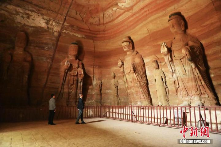 7月15日，游人參觀甘肅省平?jīng)鍪袥艽h百里石窟長廊中的南石窟寺1號窟。百里石窟長廊位于涇川縣境內(nèi)，由512個石窟、5眼窟中石井組成，現(xiàn)存王母宮石窟、鳳凰山石窟、南石窟寺、丈八寺石窟、羅漢洞石窟、太山寺石窟等規(guī)模較大的石窟群，還有數(shù)量眾多的小石窟群。南石窟寺開鑿于北魏永平三年，其中1號窟屬于大型七佛窟，七佛高達6米。中新社記者 李亞龍 攝