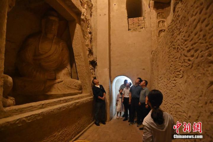 7月15日，游人參觀甘肅省平?jīng)鍪袥艽h百里石窟長廊中的王母宮石窟。百里石窟長廊位于涇川縣境內(nèi)，由512個石窟、5眼窟中石井組成，現(xiàn)存王母宮石窟、鳳凰山石窟、南石窟寺、丈八寺石窟、羅漢洞石窟、太山寺石窟等規(guī)模較大的石窟群，還有數(shù)量眾多的小石窟群。王母宮石窟又名千佛洞，該窟設計宏大，造像生動，窟內(nèi)擁有造像數(shù)百尊，是較為珍貴的佛教文化歷史遺存。中新社記者 李亞龍 攝</p>
<p>