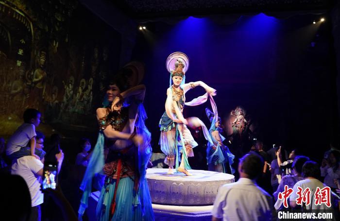 《樂(lè)動(dòng)敦煌》是全球首部洞窟式沉浸體驗(yàn)劇，利用真人與數(shù)字影像虛實(shí)交換實(shí)現(xiàn)沉浸式體驗(yàn)。圖為2023年8月28日晚，《樂(lè)動(dòng)敦煌》演出。(資料圖)中新社記者 毛建軍 攝