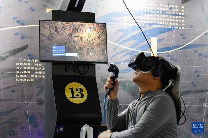 7月22日，游客借助VR設(shè)備沉浸式游覽莫高窟第285窟虛擬場(chǎng)景。新華社記者 郎兵兵 攝